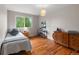 Bright bedroom with hardwood floors, large window, and classic wooden furniture at 6918 E Long Ave, Centennial, CO 80112