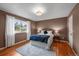 Cozy bedroom featuring hardwood floors, a large window offering natural light, and a comfortable queen-sized bed at 6918 E Long Ave, Centennial, CO 80112