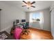 Bright bedroom featuring hardwood floors, a ceiling fan, and a large window with natural light at 6918 E Long Ave, Centennial, CO 80112