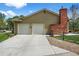 Two-car garage with a brick chimney, concrete driveway, and fenced-in yard at 6918 E Long Ave, Centennial, CO 80112