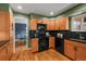 Charming kitchen featuring wood cabinets, black countertops, and modern appliances with great natural light at 6918 E Long Ave, Centennial, CO 80112