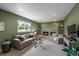 Bright living room featuring a cozy fireplace, large window overlooking the greenery, and comfortable seating at 6918 E Long Ave, Centennial, CO 80112