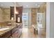 Luxurious bathroom featuring a granite countertop double vanity and glass-enclosed shower with tub at 7600 Landmark Way # 1215, Greenwood Village, CO 80111