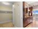 Bright bathroom boasts wood cabinets, granite countertops, and access to a walk-in closet and bedroom at 7600 Landmark Way # 1215, Greenwood Village, CO 80111