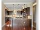 Gourmet kitchen boasts dark wood cabinetry, stainless steel appliances, and center island with stone countertops at 7600 Landmark Way # 1215, Greenwood Village, CO 80111