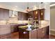 The kitchen features granite countertops, dark cabinetry, a center island with pendant lighting, and stainless appliances at 7600 Landmark Way # 1215, Greenwood Village, CO 80111