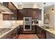 Modern kitchen featuring granite countertops, stainless steel appliances, wine fridge, and ample cabinet space at 7600 Landmark Way # 1215, Greenwood Village, CO 80111