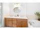 Bathroom features double sinks, tub, neutral tile and wood vanity at 2304 S Holly St # A, Denver, CO 80222
