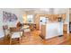 Sunlit eat-in kitchen area with hardwood floors, glass table, and natural wood cabinets at 2304 S Holly St # A, Denver, CO 80222