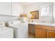 Bright laundry room includes washer, dryer, sink, storage and countertop at 2304 S Holly St # A, Denver, CO 80222
