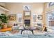 Cozy living room with a fireplace, high ceilings, and bright natural light from large windows at 2304 S Holly St # A, Denver, CO 80222