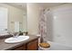 Bathroom featuring a single sink vanity, a toilet, and a shower-tub combo with a floral shower curtain at 7662 Bristolwood Dr, Castle Pines, CO 80108