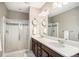 Bathroom features a double vanity, a large mirror and a glass enclosed shower at 10066 Belvedere Cir, Lone Tree, CO 80124