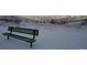 Metal bench in a snow covered park with a view of city lights at night at 10066 Belvedere Cir, Lone Tree, CO 80124