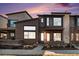 Inviting two-story home with modern brick design and large windows, complemented by manicured front yard landscaping at 10066 Belvedere Cir, Lone Tree, CO 80124
