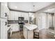 Bright kitchen with stainless appliances, island seating, white cabinets, and modern backsplash at 10066 Belvedere Cir, Lone Tree, CO 80124