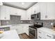 Updated kitchen featuring white cabinetry, stainless appliances, and modern mosaic tile backsplash at 10066 Belvedere Cir, Lone Tree, CO 80124
