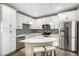 Stylish kitchen features white cabinets, stainless appliances, island with seating, and backsplash at 10066 Belvedere Cir, Lone Tree, CO 80124
