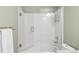 Bright bathroom featuring a shower-tub combination with a glass door at 445 Brendon Ct, Castle Pines, CO 80108