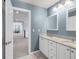 Hall bathroom with double sinks, white cabinets and a view of the hallway and living space at 445 Brendon Ct, Castle Pines, CO 80108