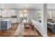 Bright dining area featuring a long wood table, stylish chairs, and an open layout to the kitchen and living room at 445 Brendon Ct, Castle Pines, CO 80108