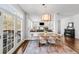 Dining area with wood table, chairs, stylish lighting, and French doors leading to a deck and open to the living room at 445 Brendon Ct, Castle Pines, CO 80108