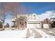Brick home featuring a 3-car garage and a charming covered entryway, set against a winter landscape at 445 Brendon Ct, Castle Pines, CO 80108