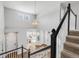 Bright foyer with hardwood floors, a decorative chandelier and an open staircase at 445 Brendon Ct, Castle Pines, CO 80108