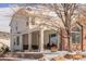 Charming two-story home with brick and stucco, a covered porch, and manicured landscaping in winter at 445 Brendon Ct, Castle Pines, CO 80108
