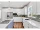 Kitchen featuring white cabinetry, stainless steel appliances, a center island, and a stylish backsplash at 445 Brendon Ct, Castle Pines, CO 80108
