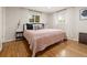 Bright bedroom with hardwood floors, a cozy queen-sized bed, and natural light from two windows at 537 S Grape St, Denver, CO 80246