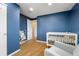 Charming blue Bedroom with a crib, reading chair, and ample natural light at 537 S Grape St, Denver, CO 80246
