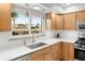 The kitchen features wood cabinets, white counters, stainless appliances, and natural light from the window at 537 S Grape St, Denver, CO 80246