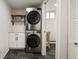 Efficient laundry area with stacked washer/dryer, storage, and stylish tiling at 537 S Grape St, Denver, CO 80246