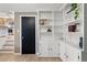 Bright living room with white built-in shelves, neutral colors, and view into kitchen area at 537 S Grape St, Denver, CO 80246