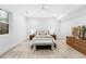 This bright bedroom is furnished with a Queen bed, bench, side tables, and ceiling fan at 4752 Eliot St, Denver, CO 80211