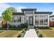 Modern home featuring a flat roof, a well-manicured lawn, and a concrete walkway leading to the front door at 4752 Eliot St, Denver, CO 80211