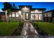 Modern home at dusk featuring manicured lawn, landscape lighting, and a walkway leading to the front door at 4752 Eliot St, Denver, CO 80211