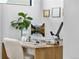 Bright office space with natural wood desk, potted plant, and mountain views on the computer screen at 4752 Eliot St, Denver, CO 80211