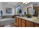 Bathroom featuring a soaking tub, double vanity, window and tile accents at 17018 Carr Ave, Parker, CO 80134