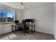 Well-lit bedroom with large window, ceiling fan, neutral carpet and a modern desk setup at 17018 Carr Ave, Parker, CO 80134
