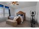 A comfy bedroom featuring a vaulted ceiling, ceiling fan, and large window with blue curtains at 17018 Carr Ave, Parker, CO 80134