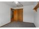 A cozy bedroom featuring gray carpeting and a spacious closet with wooden doors at 17018 Carr Ave, Parker, CO 80134