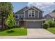Charming two-story home features a well-manicured lawn, gray siding and a spacious two car garage at 17018 Carr Ave, Parker, CO 80134