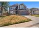 Charming two-story home featuring blue siding, brick accents, an attached two-car garage, and a well-maintained front yard at 17018 Carr Ave, Parker, CO 80134