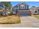Charming two-story home featuring blue siding, brick accents, an attached two-car garage, and a well-maintained front yard at 17018 Carr Ave, Parker, CO 80134