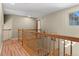 Upstairs hallway with wood floors and staircase leading down, bright with natural light at 17018 Carr Ave, Parker, CO 80134