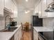 Updated kitchen with white cabinets, modern appliances, and a view of the dining area at 309 E Highline Cir # 104, Centennial, CO 80122