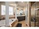 Stylish main bathroom with soaking tub, glass shower, and dual sink vanity at 7007 S Garrison St, Littleton, CO 80128
