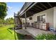 Covered outdoor patio with grilling station and adjacent backyard with well maintained lawn at 7007 S Garrison St, Littleton, CO 80128